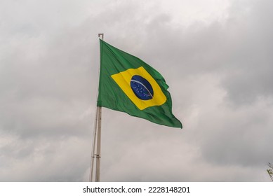 Brazilian flag flying on an iron bar. National symbol. Pavilion. Symbol of the Federative Republic of Brazil. coat of arms. National identity. Green and yellow flag. - Powered by Shutterstock