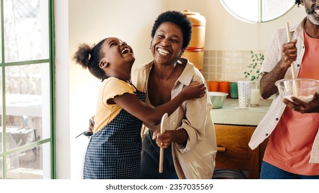 Brazilian girl and her mom laughing happily, sharing a special bonding moment in the kitchen. Young daughter wearing an apron, having fun with her family while baking. - Powered by Shutterstock