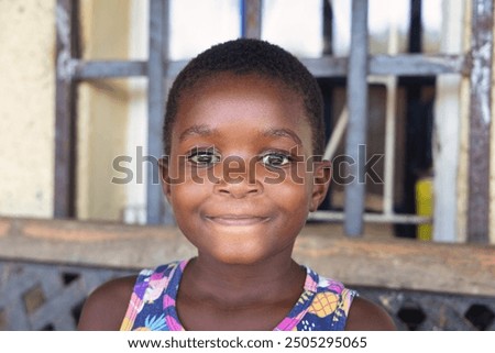 Brazilian girl poverty sitting on the bench in front of the burglar bars at home. Favela is an umbrella name for several types of working class neighborhoods in Brazil