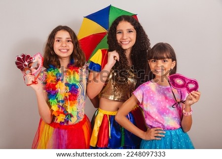 Brazilian girls friends, dressed in carnival clothes smiling for photo.