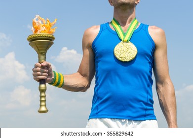 Brazilian Gold Medal Athlete Standing With Sport Torch In Front Of Blue Sky In Rio De Janeiro, Brazil 