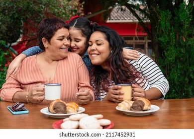 brazilian granddaughter hugging granny and mom during breakfast outside in the garden - Powered by Shutterstock