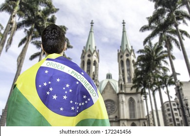 Brazilian Holding A Brazilian Flag Looks To Se Cathedral In Sao Paulo, Brazil