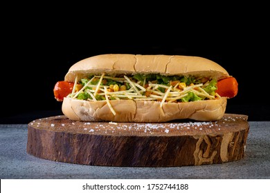 Brazilian hot dog with bread, straw potatoes, ketchup, mayo and lettuce