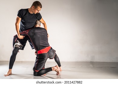 Brazilian jiu jistu bjj no-gi grappling training two male athletes drilling technique takedown wrestling copy space - Powered by Shutterstock