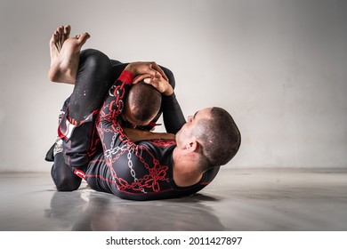 Brazilian jiu jistu bjj no-gi grappling training two male athletes drilling technique triangle submission choke copy space
