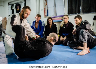 Brazilian Jiu jitsu bjj black belt teaching class or private lessons to his students at the academy martial arts ground fight