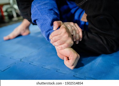 Brazilian Jiu Jitsu BJJ Jiujitsu Training Sparring Athlete Fighter Applying Kimura Or Americana Shoulder Lock Submission On His Opponent During Technique Practice