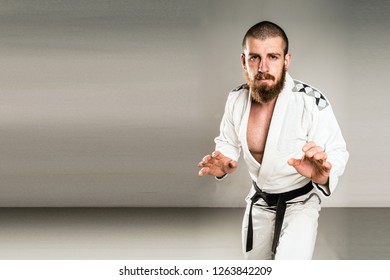 Brazilian Jiu Jitsu Judo Black Belt In A Fighting Stance Wearing White Gi Kimono