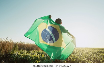 Brazilian little kid - football fan, child patriot with national flag on sky background at summer sunset. Brazil celebration banner, holidays in America. High quality - Powered by Shutterstock