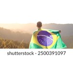 Brazilian man with the Brazilian flag on his back and arm raised to express national pride and celebration of Brazil