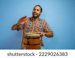 A Brazilian man playing a rhythm instrument. Carnival feelings. Conga drum. Atabaque.