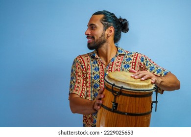 A Brazilian man playing a rhythm instrument. Carnival feelings. Conga drum. Atabaque.