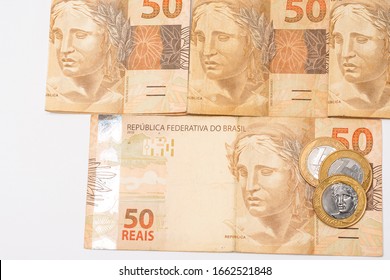  Brazilian Money, 50 Reais Notes 
 And Coins On Banknotes, Financial Health.
On A White Background