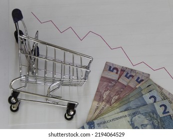 Brazilian Money And Shopping Cart On A Downward Trend Graph