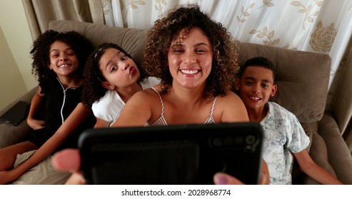 Brazilian mother and kids take selfie photo on couch with smartphone - Powered by Shutterstock