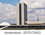 The Brazilian National Congress building in Brasilia under a partly cloudy sky.
