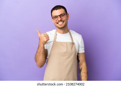 Brazilian restaurant waiter over isolated purple background pointing to the side to present a product - Powered by Shutterstock