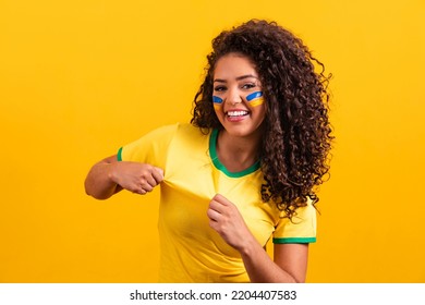 Brazilian supporter. Brazilian woman fan celebrating on soccer or football match on yellow background. Brazil colors. - Shutterstock ID 2204407583