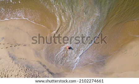 Brazilian woman in bikini lying on the sand on a deserted beach in Ubatuba, São Paulo, Brazil.
Atlantic forest, yellow sand and clear sea water. Figueira beach paradise. top view