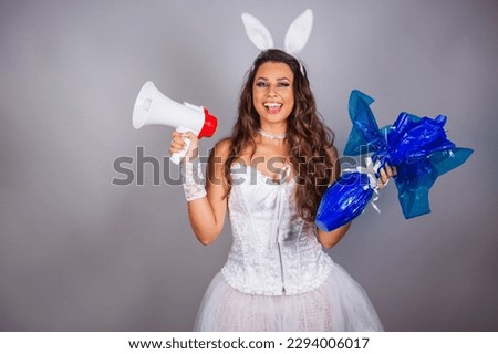 Brazilian woman, with bunny clothes. holding easter egg and megaphone.