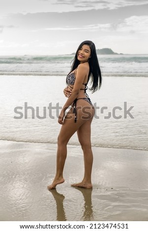 Brazilian woman on a beach in summer in a bikini