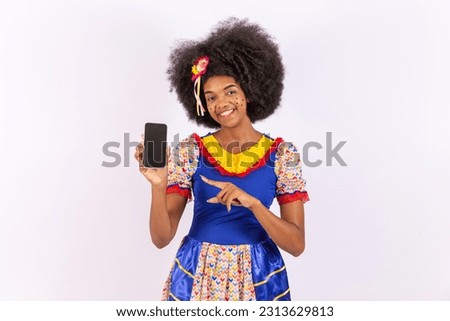 brazilian woman wearing typical clothes of festa junina, arraial, festa de são joão. with smartphone.