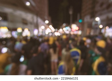 Brazilians With The Flag And Green And Yellow Clothes Celebrating At Night In The Street. Santos, Brazil. Blurred Image.