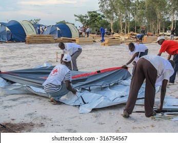 Brazzaville, Congo - May 1st 2012: Red Cross Workers Putting Up A Tent In A New Refugee Camp In Congo, Central Africa