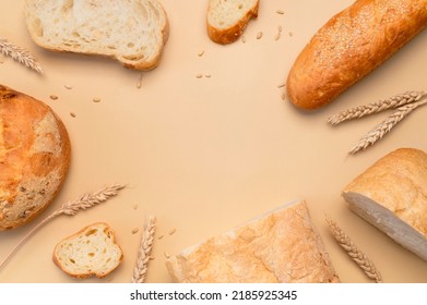 Bread Background. Fresh White Wheat Bread, Round Classic, Ciabatta, French Baguette, Wheat Ears And Grains On Beige Background Flat Lay Top View. Bread Making, Bakery, Healthy Food. Light Mockup