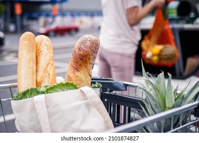 Bread And Baguettes In The Shopping Cart. Woman Loading Groceries In Reusable Mesh Bags Into Car Trunk. Zero Waste And Plastic Free Shopping