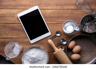  bread bakery ingredients with kitchenware and tablet on wooden table. flat lay top view