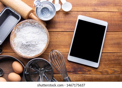  bread bakery ingredients with kitchenware and tablet on wooden table. flat lay top view