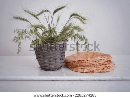 Bread, basket with ears of corn on a white table, background for presentations, wallpaper, still life, background image, photo of bread