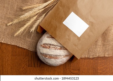 Bread in the blank paper bag with label, bakery branding mockup, empty space to display your logo or design.