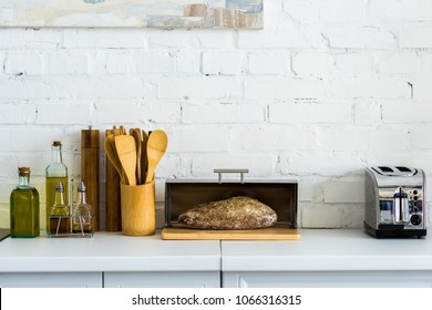 bread in breadbasket and toaster on kitchen counter