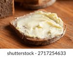 Bread and butter. Closeup view slice of rye bread spreaded with butter