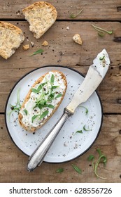 Bread With Cream Cheese, Cress And Pepper Together With A Plate And A Knife On An Old Rustic Wooden Background