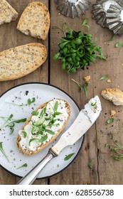 Bread With Cream Cheese, Cress And Pepper Together With A Plate And A Knife On An Old Rustic Wooden Background