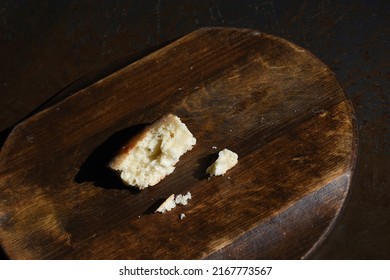 Bread Crumbs On A Wooden Kitchen Board On Dark Background. Isolated. Need Food. War, Hunger, Poverty, Economic Crisis And Social Inequality.