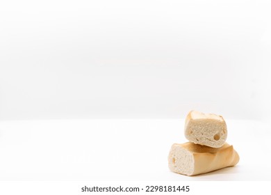Bread cut in half on a white background. Bread slices and crumbs seen from the front, selective focus