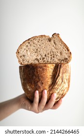 bread cut into 2 halves is held by a girl on a white background