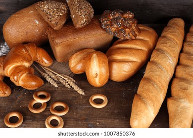 Bread of different kinds on the table. Baking of dough on a dark wooden surface top view