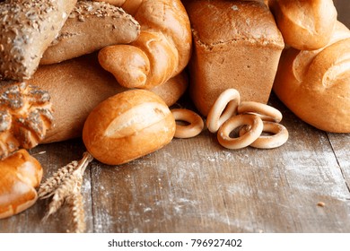 Bread of different kinds on the table. Baking of dough on a dark wooden surface top view