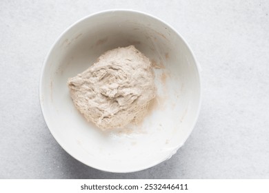 Bread dough being mixed in a ceramic bowl, Beet Focaccia dough in a white bowl, process of making pink focaccia