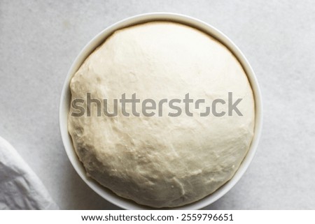 Bread dough that has doubled in size, dough that has risen, proofed dough in a white bowl