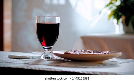 Bread and glass chalice of a red wine situated on a Communion table (The Lord’s Supper - communion under both kinds) - Shutterstock ID 1445183591