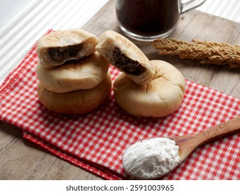 Bread with green bean paste filling, served on a wooden cutting board with coffee, on a white background.