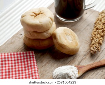 Bread with green bean paste filling, served on a wooden cutting board with coffee, on a white background.