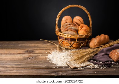 bread loaves and sliced ​​bread with wheat seeds placed on a dark brown wooden table on a black background in a rustic kitchen or bakery There is a copy space - top view. - Powered by Shutterstock